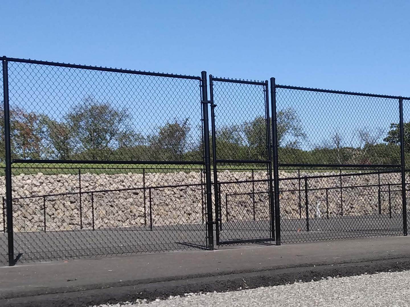 Black chain link fence with gate installed on a commercial property