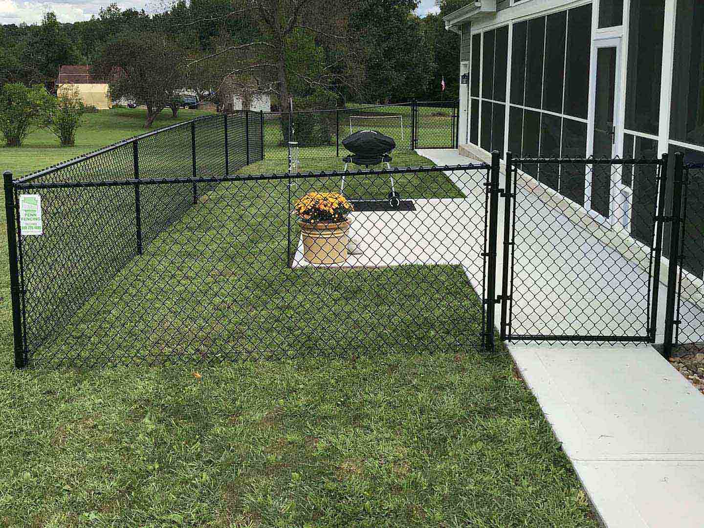 Black chain link fence with gate installed in a residential back yard in Butler Pennsylvania