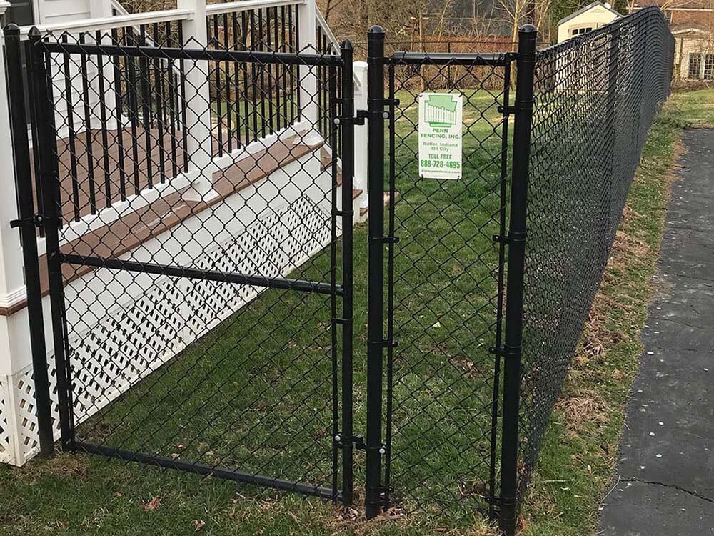 Black chain link fence with gate installed in Western Pennsylvania around a home