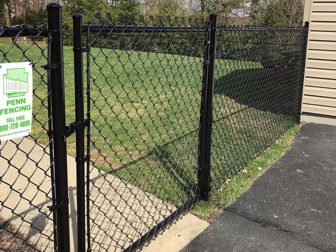 Black chain link fence with gate next to a residential property in Western Pennsylvania