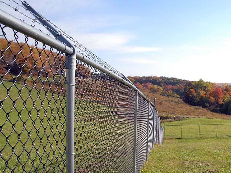 Chain link fence with barbed wire installed on a commercial property in Western PA