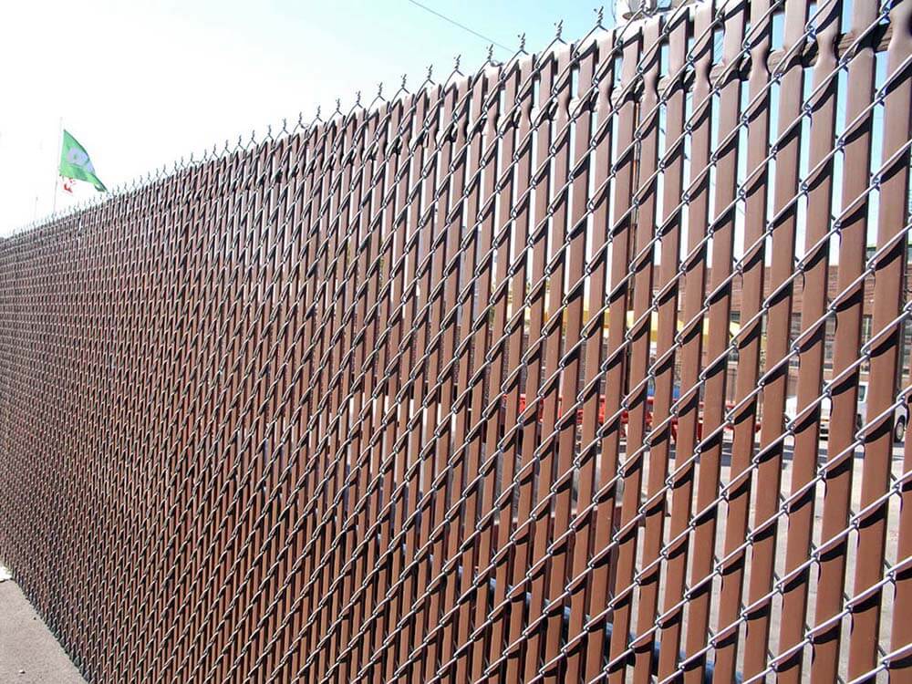 Commercial chain link fence with brown privacy slates installed in Western Pennsylvania