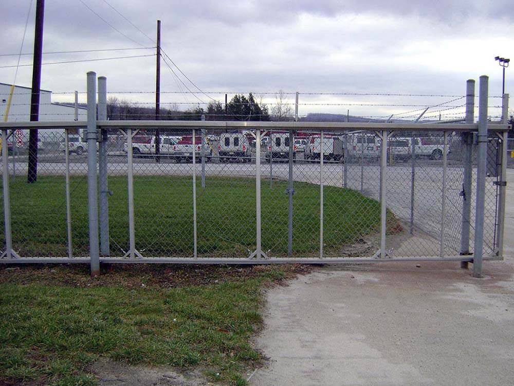 Commercial chain link sliding gate with barbed wire installed in Western PA