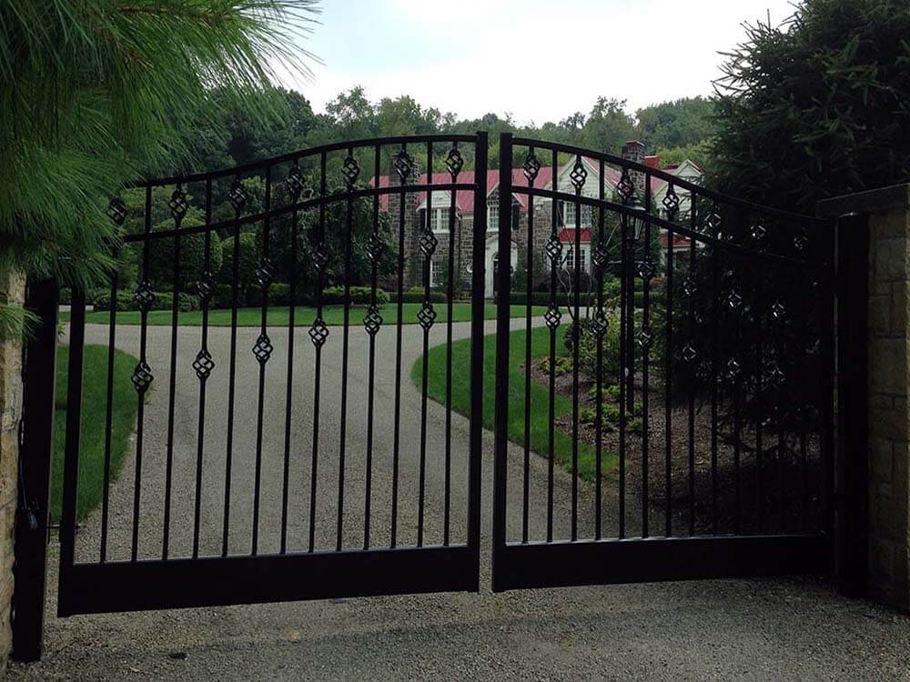 Custom metal double swing gate with ornate posts installed in Western PA as entry to a residence