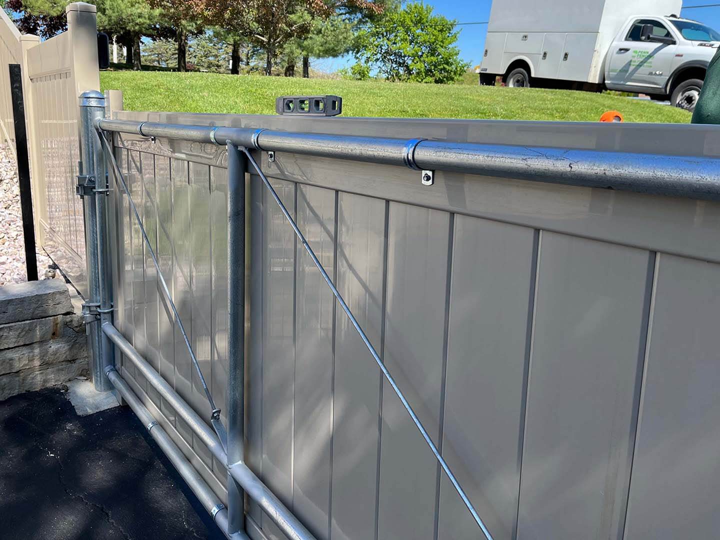 Tan full privacy slide gate installed by a Butler Pennsylvania fence company for access control