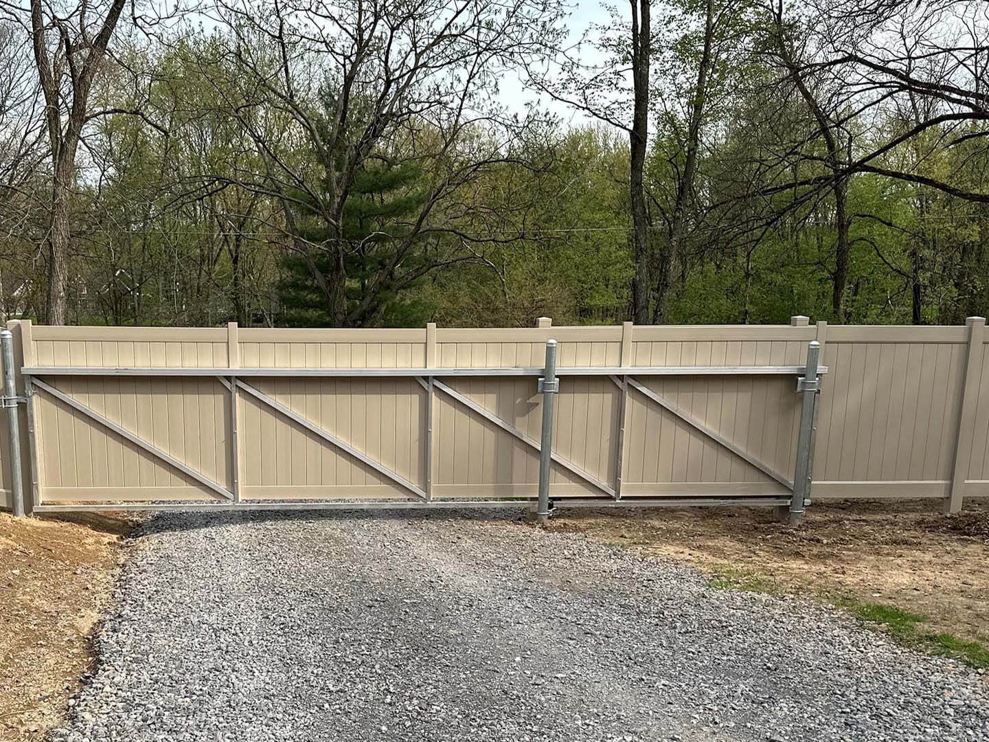 Tan Vinyl fence with gate for privacy installed on a gravel road in Butler Pennsylvania