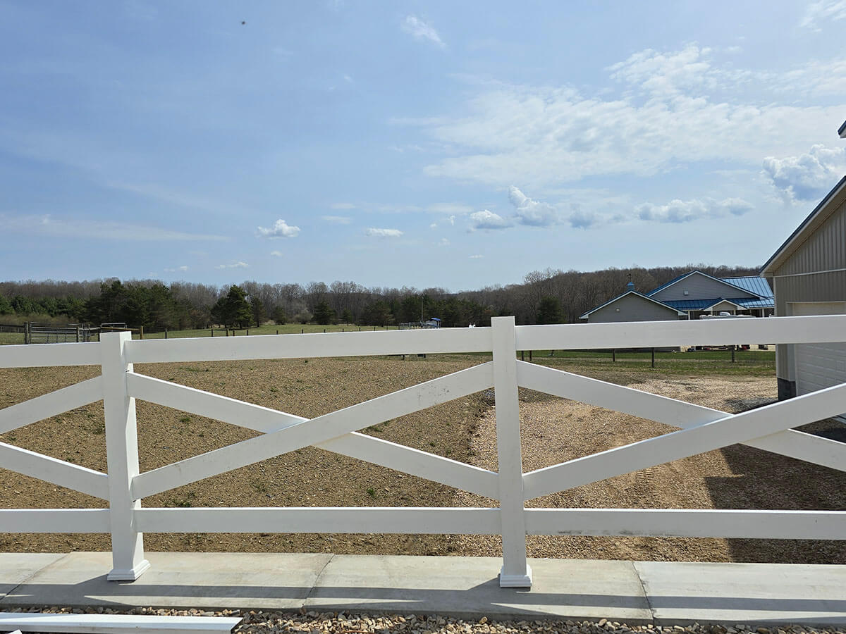 White Vinyl Crossbuck Fence Installed Along Sloped Property in Western Pennsylvania