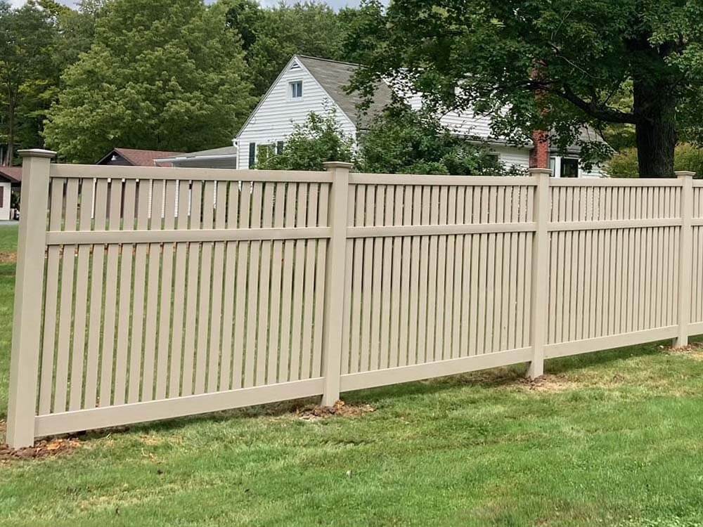 Tan vinyl spaced picket fence installed in Western PA on a residential property