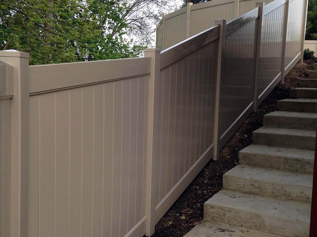 Full privacy vinyl fence installed along a residential staircase in Western PA