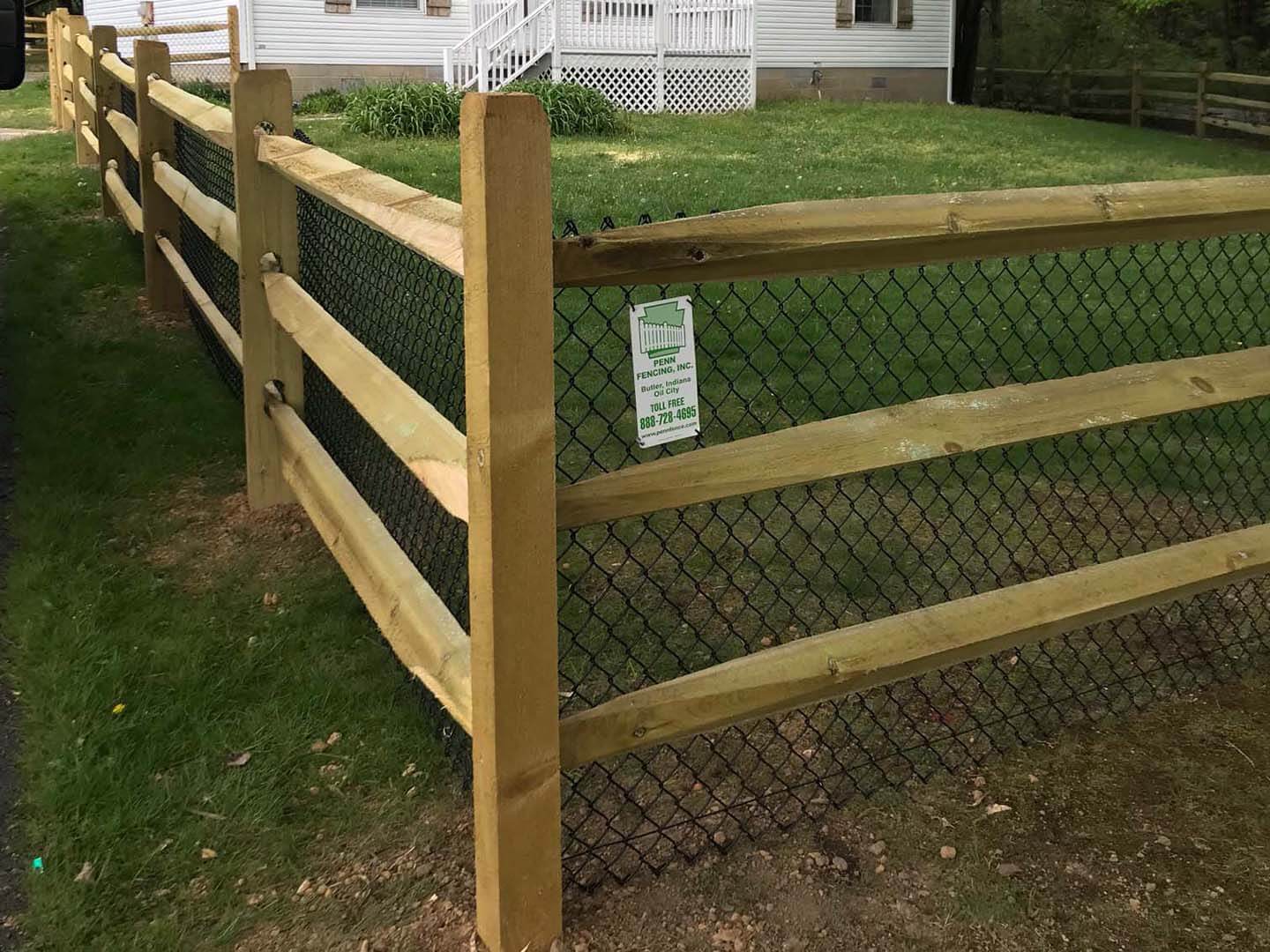 Split rail wood fence with wire mesh installed at a residential property in Butler Pennsylvania