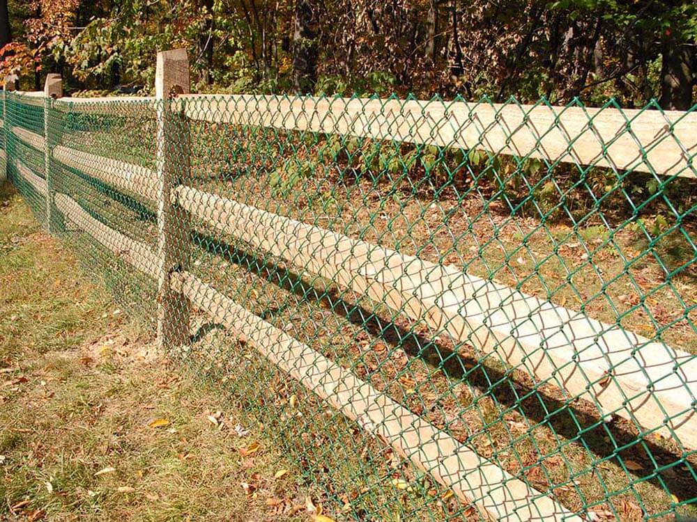 Split rail fence with green chain link installed along a property in Western Pennsylvania