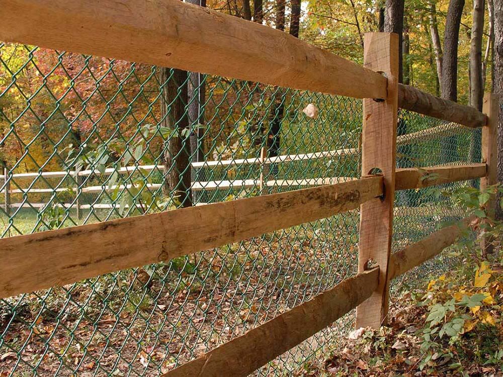 Split rail wood fence with green chain link installed around a home in Western PA